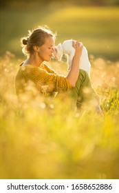 Pretty, Young Woman With Her Cat Pet Sitting In Grass On Lovely Meadow Lit By Warm Evening Light (shallow DOF; Color Toned Image)