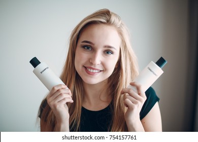 Pretty Young Woman Hold Two Bottle With Empty Space. Shampoo And Conditioner.