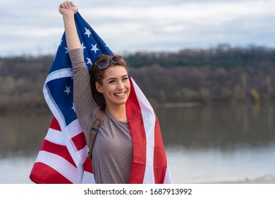 Pretty young woman holding american flag - Powered by Shutterstock