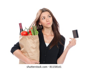 Pretty young woman holding a shopping bag full of vegetarian groceries in supermarket with tomatoes, asparagus, bottle of red wine and credit card isolated on white background - Powered by Shutterstock