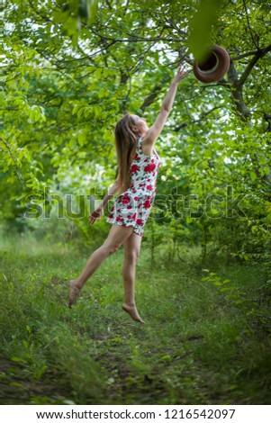 pretty young woman jumping on green park