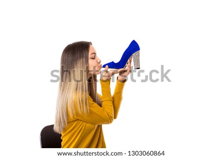 Pretty young woman kissing a high heel shoe over white background