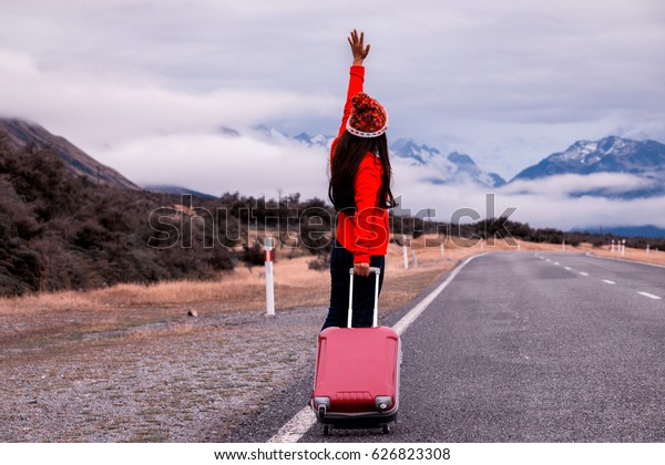 Pretty young woman with\
luggage, hitchhiking along a road. (hitchhiker, travel,\
traveler),vintage tone\
