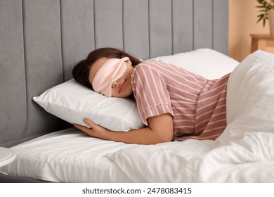 Pretty young woman with mask sleeping in bed - Powered by Shutterstock