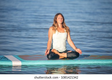 Pretty young woman in meditation on the water in Waikiki