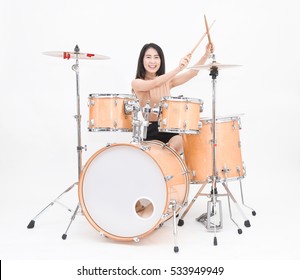 Pretty young woman playing drum set (isolated on white background)