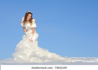 Pretty Young Woman Posing In Wedding Dress With Train, On Winter Snow