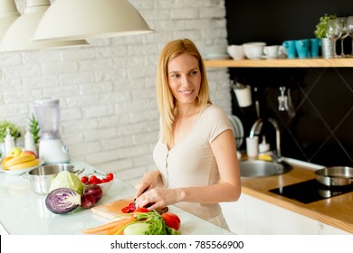 Pretty young woman preparing healthy meal in the modern kitchen - Shutterstock ID 785566900