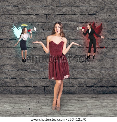Pretty young woman in red dress thinks, an angel and a devil on grey brick background
