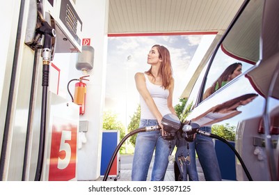 Pretty young woman refuel the car - Shutterstock ID 319587125