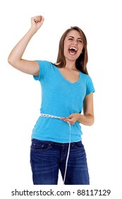 Pretty Young Woman Rejoicing Over Weight Loss Success. One Hand Holds A Tape Measure, The Other Is Raised In Triumph As She Shouts For Joy At Her Accomplishment