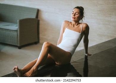 Pretty Young Woman Relaxing On The Poolside Of Indoor Swimming Pool