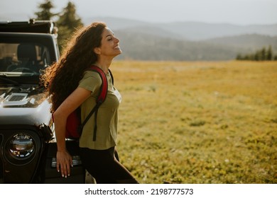 Pretty Young Woman Relaxing On A Terrain Vehicle Hood At Countryside