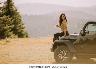 Pretty Young Woman Relaxing On A Terrain Vehicle Hood At Countryside