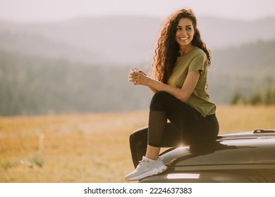 Pretty Young Woman Relaxing On A Terrain Vehicle Hood At Countryside