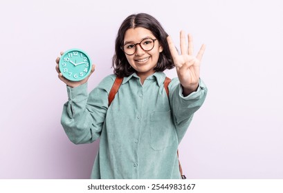 pretty young woman smiling and looking friendly, showing number four. alarm clock concept