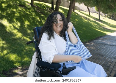 Pretty young woman smiling in wheelchair with her bag - Powered by Shutterstock