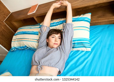 Pretty Young Woman Stretching After Lying In Her Bed All Day Long