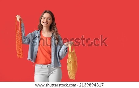 Pretty young woman with string bags on red background