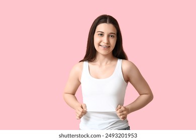 Pretty young woman in stylish white tank top on pink background - Powered by Shutterstock