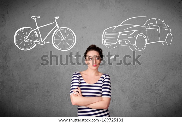 Pretty young woman taking a decision between bicycle\
and car