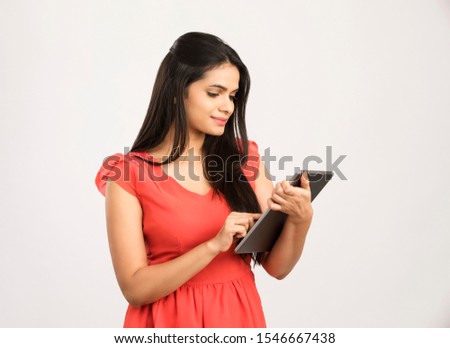 Pretty young woman using digital tablet on white.
