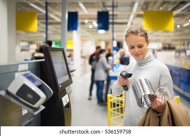 Pretty, young woman using self service checkout in a store (shallow DOF; color toned image)