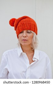Pretty Young Woman In Warm Orange Beanie Wool Knitted Hat.