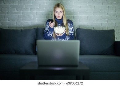 Pretty Young Woman Watching Movie On Her Laptop In Bed In A Dark Room Watching Movie Late Night.