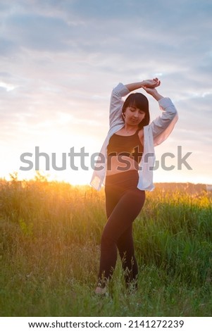 Similar – Beautiful young photographer woman wearing black clothes, sitting on the floor in countryside with her camera