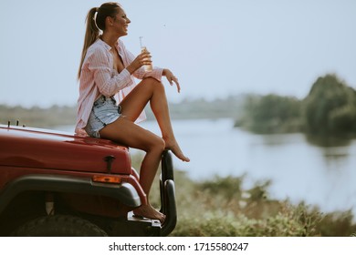 Pretty Young Women Drinking Cider On The Vehicle At The Lakeside