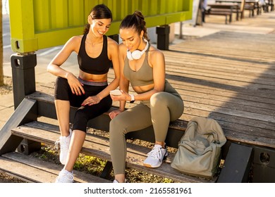 Pretty Young Women In Sportswear Looking At Mobile Phone After Exercise Training