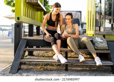 Pretty Young Women In Sportswear Looking At Mobile Phone After Exercise Training