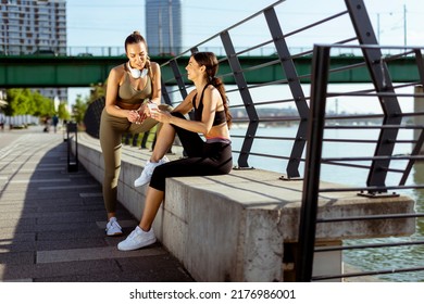 Pretty Young Women In Sportswear Looking At Mobile Phone After Exercise Training