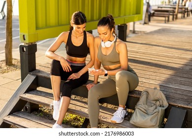 Pretty Young Women In Sportswear Looking At Mobile Phone After Exercise Training