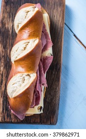 Pretzel With Roasted Beef And Cheese, Sandwich For Lunch. Served On Wooden Board, Overhead View
