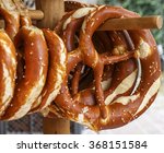 Pretzels, traditional snack for beer for Oktoberfest are hanging on the wooden stand. Volksfest, beer festival in Salzburg, Austria, Europe. Closeup