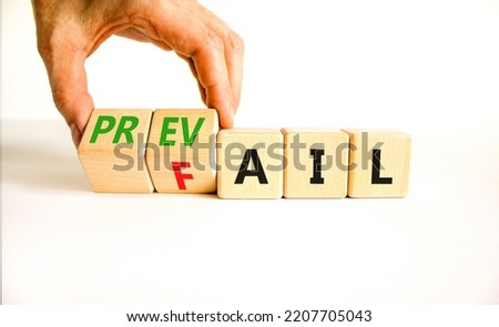Prevail or fail symbol. Concept words Prevail or Fail on wooden cubes. Businessman hand. Beautiful white table white background. Business prevail or fail concept. Copy space.