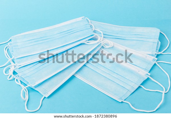 Prevent coronavirus. Medical mask, Medical\
protective mask isolated on blue background. Disposable surgical\
face mask cover mouth and nose. Healthcare medical Coronavirus\
quarantine, hygiene\
concept