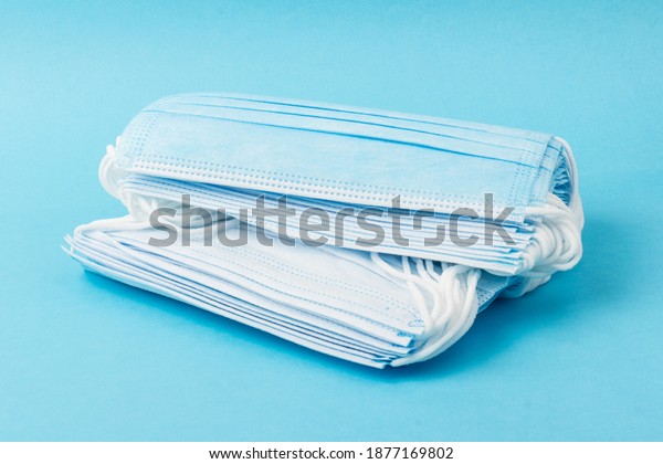 Prevent coronavirus. Medical mask, Medical\
protective mask isolated on blue background. Disposable surgical\
face mask cover mouth and nose. Healthcare medical Coronavirus\
quarantine, hygiene\
concept