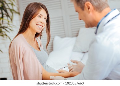 Preventative measures. Selective focus on beautiful expectant mother beaming while vising a doctor and getting vaccination. - Powered by Shutterstock