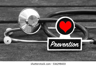 Prevention word written on blackboard with Stethoscope on wooden background - Medical Concept