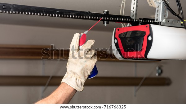 Preventive maintenance on a garage door opener chain\
with some oil