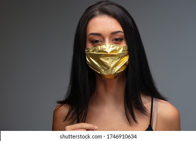 price rise of face masks and scarcity in COVID-19 times concept as a beautiful young woman wearing a face mask made of gold because she can afford it even if they are become an extremely rare good