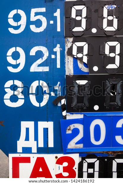 Prices on the\
information board of the petrol station. Numbers on the metal\
surface with mechanically movable covers. Cyrillic inscription:\
Diesel Fuel and Gas.