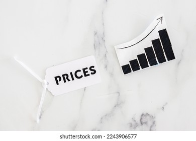 Prices text on product tag next to graph with stats going up, concept of inflation and price hikes - Shutterstock ID 2243906577