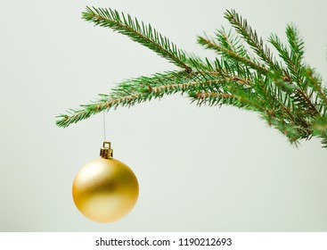 Prickly Christmas tree branch on a light background with a Christmas toy. Minimalism - Shutterstock ID 1190212693
