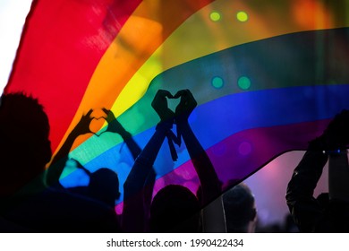 Pride Community At A Parade With Hands Raised And The LGBT Flag - Symbol Of Love And Tolerance