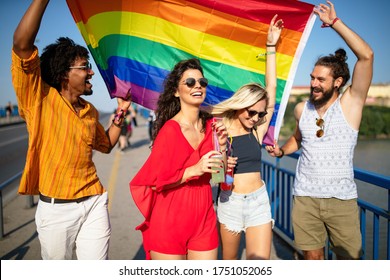 Pride Homosexual, Lesbian, Gay Community At A Parade With Hands Raised And The LGBT Flag