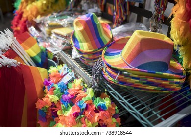 Pride LBGT Festival Merchandise Stall Featuring Symbolic Rainbow Flag Coloured Hats, Flags, Leis, Feather Boas And Other Items